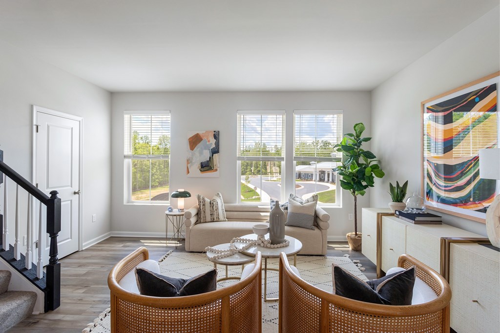 A living room with a couch, chairs, and a table.