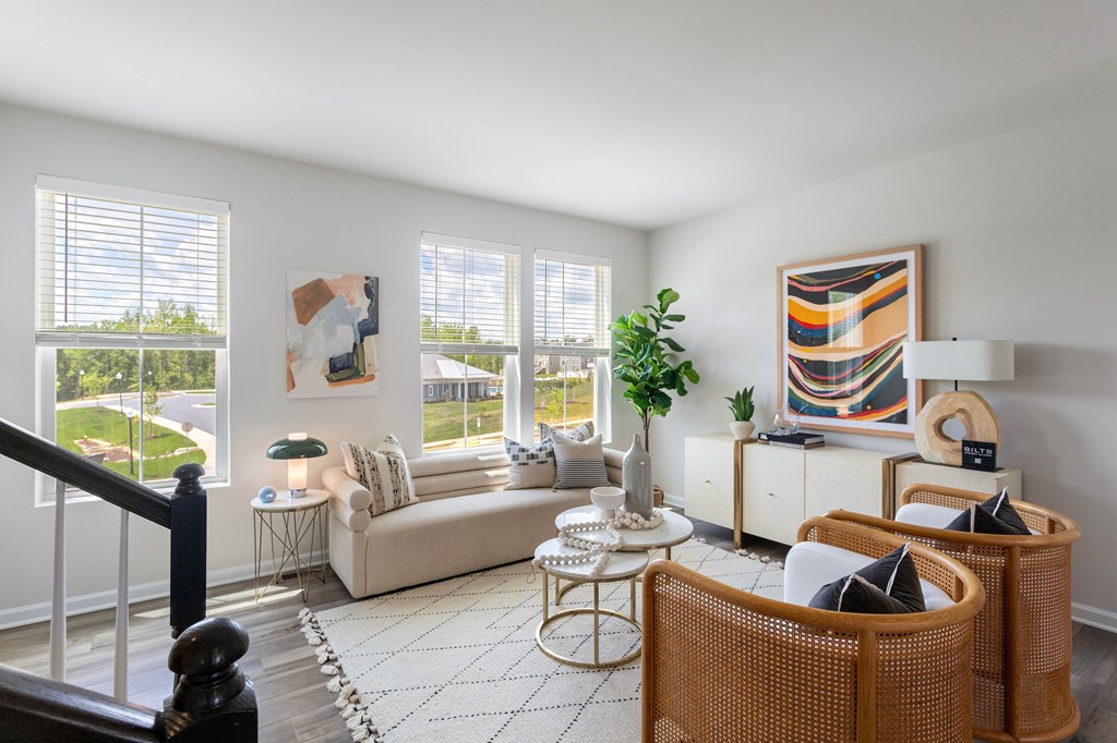 A living room with a couch, chairs, and a table.