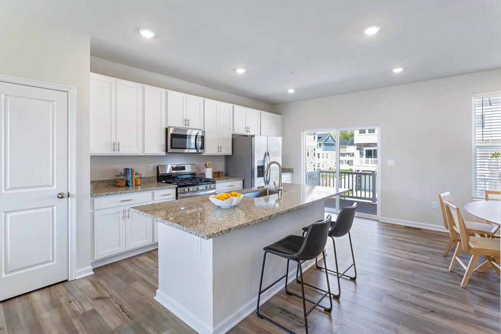 A kitchen with a granite countertop and white cabinets.