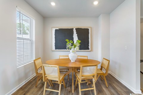 A dining room with a table and chairs.