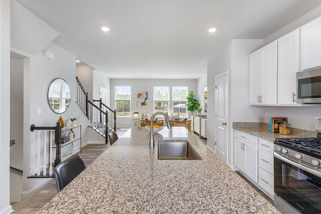 A kitchen with a granite countertop and a stainless steel sink.