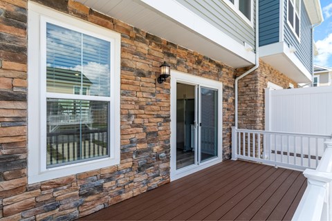 A balcony with a white railing and a sliding glass door.