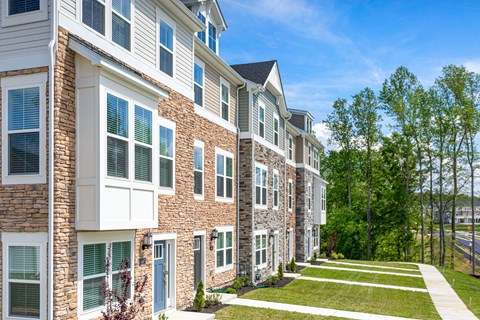 A row of houses with green lawns in front.