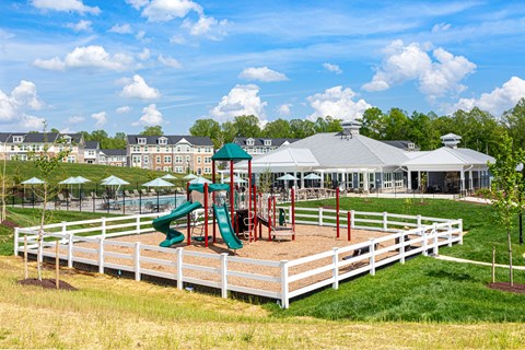 A playground with a green slide and red and green play equipment.