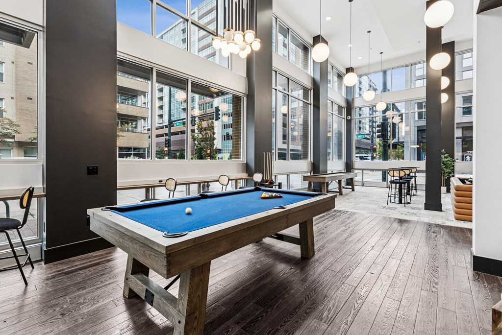 A pool table in a room with a view of the city.