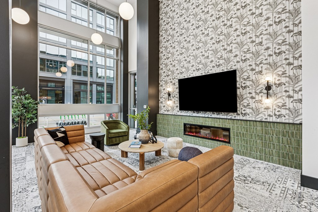 A living room with a brown leather sofa and a green chair.