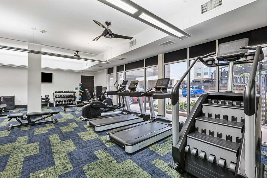 A gym with treadmills, elliptical machines, and other exercise equipment.