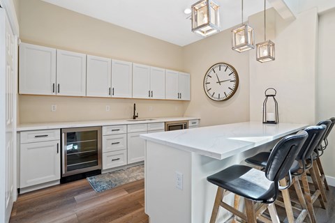 A kitchen with a white table and black chairs.