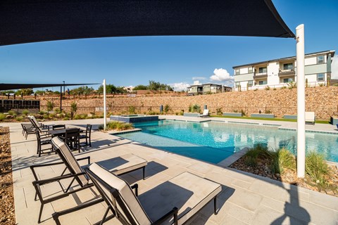 A pool with a table and chairs under a canopy.