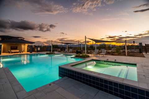 A large outdoor swimming pool with a smaller hot tub in the foreground.