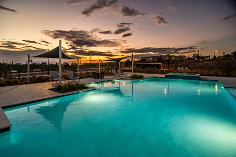 A swimming pool is lit up at dusk.