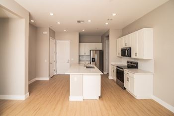 A kitchen with white cabinets and appliances.