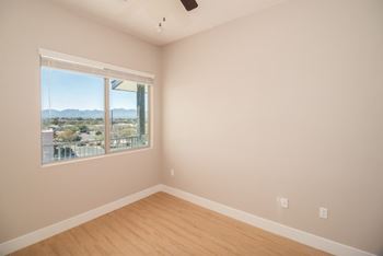 A room with a window overlooking a landscape.