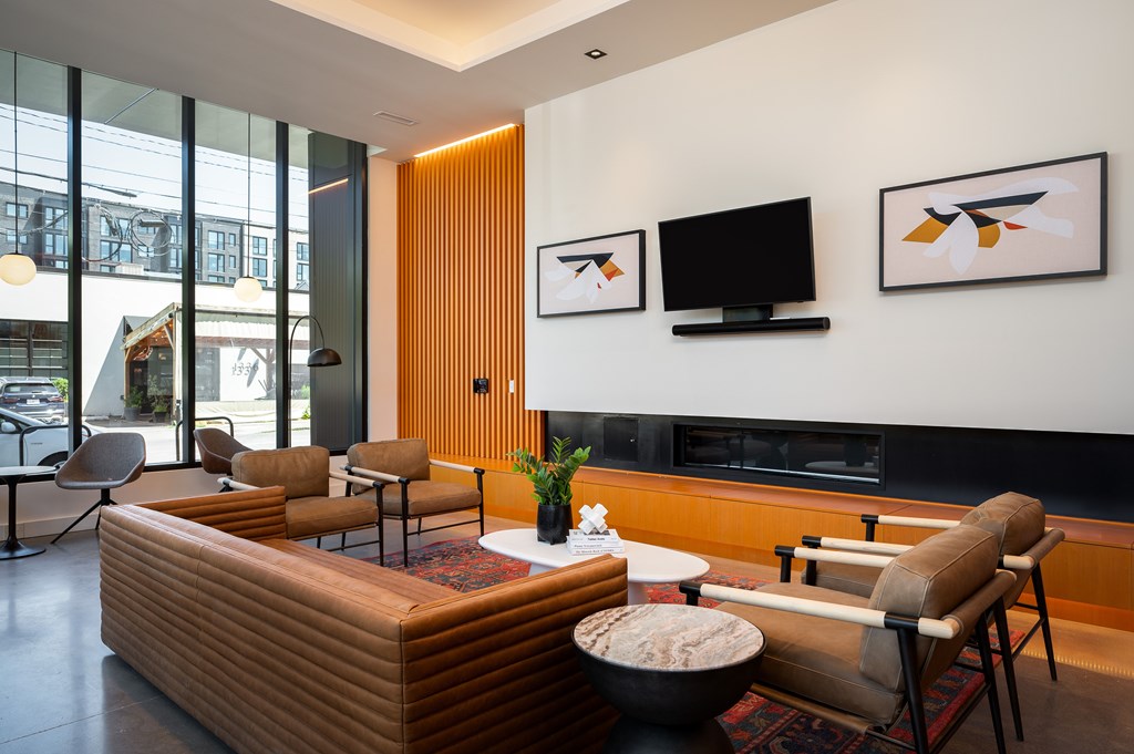 MERX Slabtown's inviting living room lobby with a brown couch and a television on the wall.