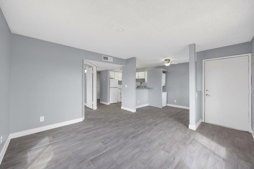 A spacious room with grey walls and wooden flooring.