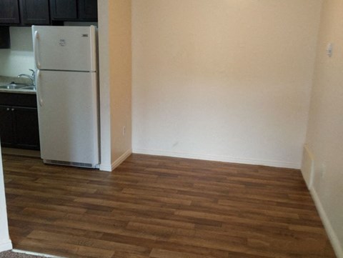 a kitchen with a refrigerator and a hard wood floor