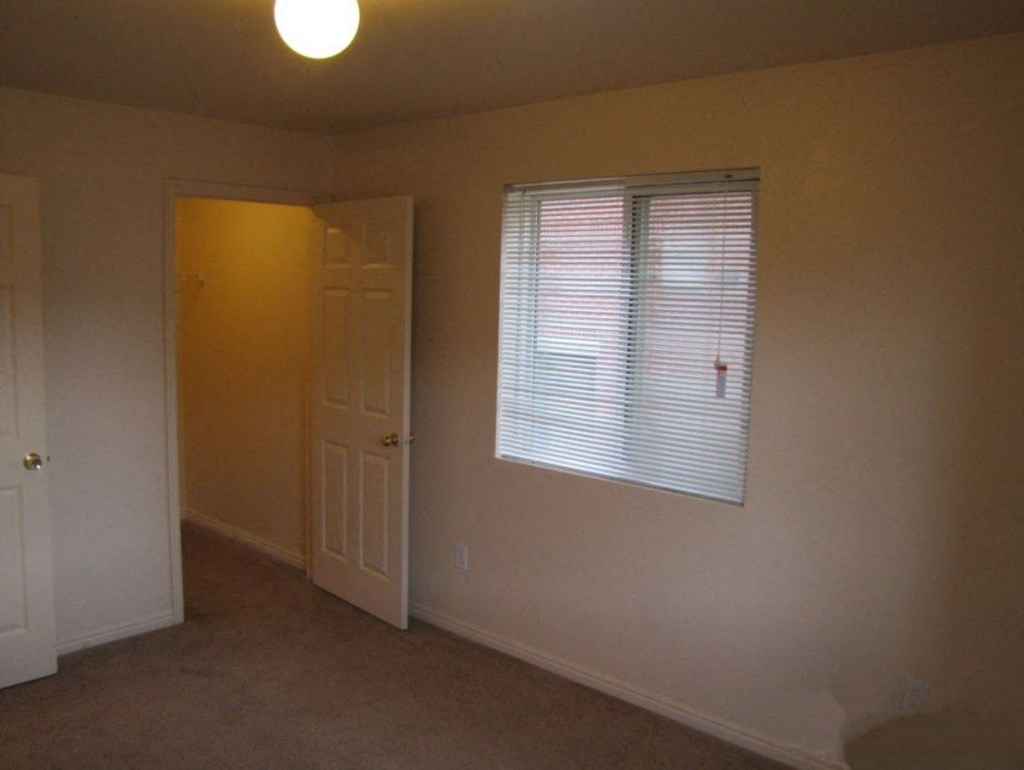 an empty room with a window and a door