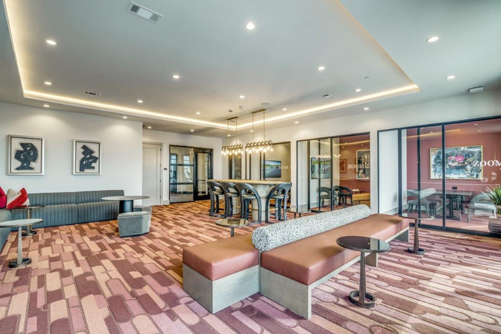 A modern lounge area with a patterned carpet and a variety of seating options.