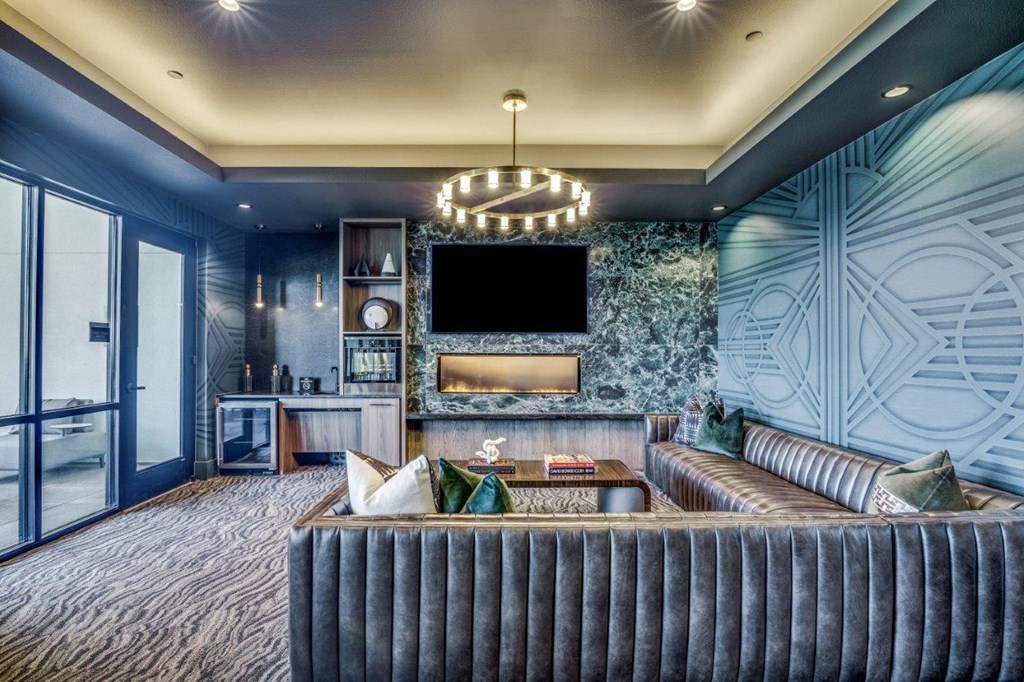A modern living room with a grey sofa and a chandelier.