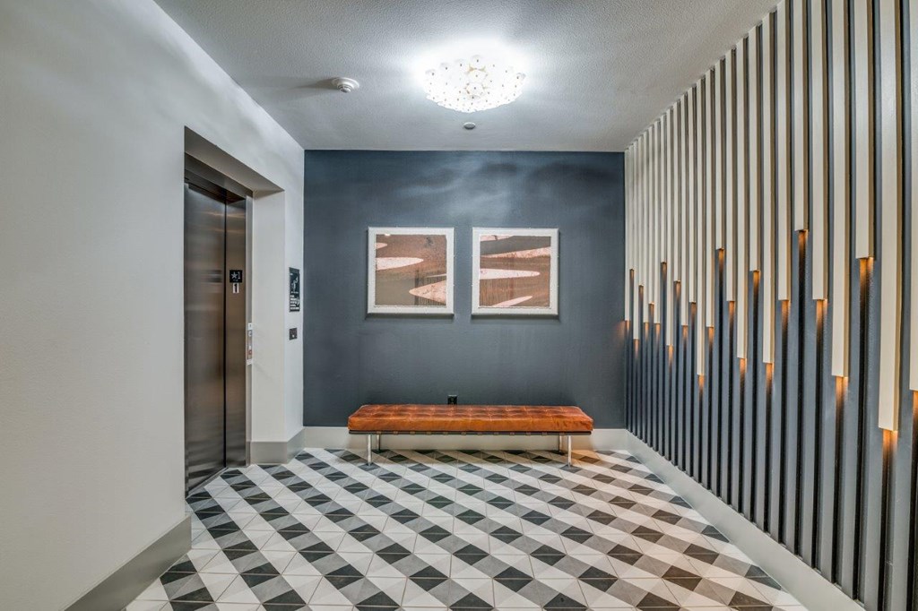 A hallway with a bench and a checkered floor.