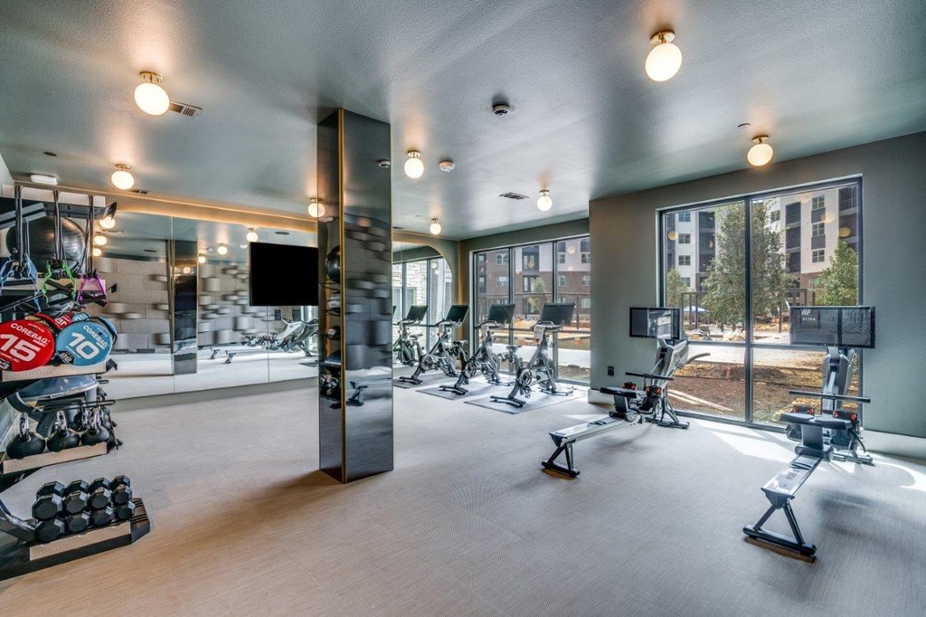 A gym with a variety of equipment including treadmills, weights, and exercise machines.