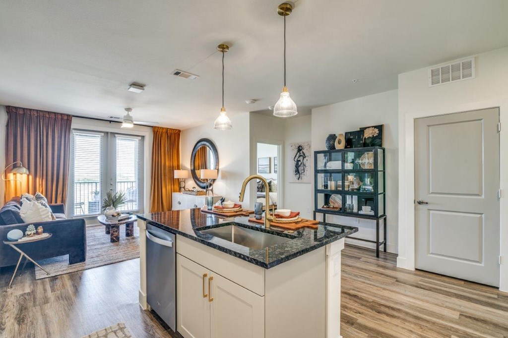 A modern kitchen with a black countertop and white cabinets.