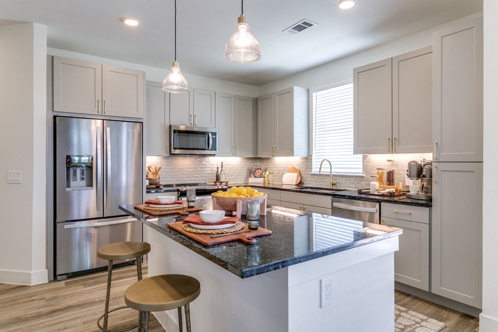 a kitchen with a large island and stainless steel appliances