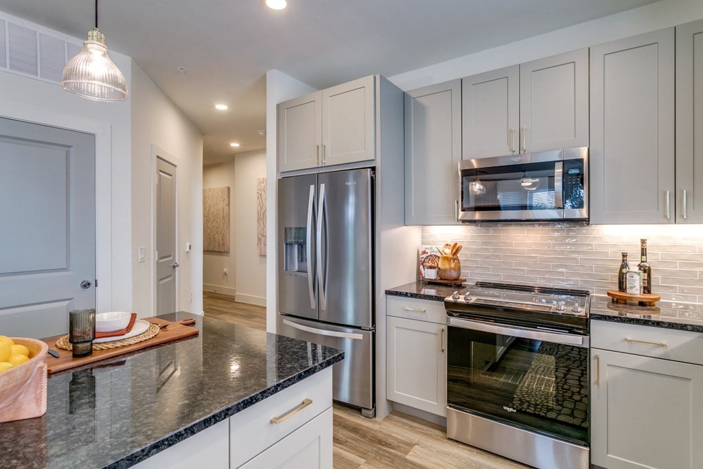 a kitchen with stainless steel appliances and white cabinets