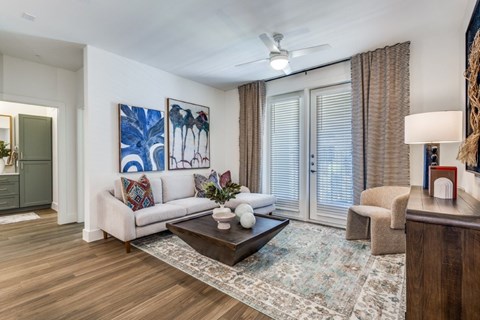 A living room with a white couch, a coffee table, and a painting on the wall.