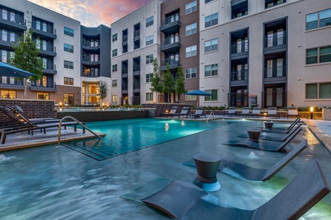 A large swimming pool in front of apartment buildings.