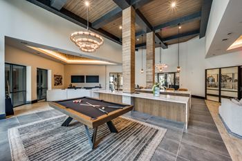 A room with a pool table and a bar.