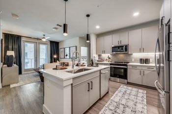 A modern kitchen with white cabinets and stainless steel appliances.