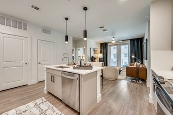 A modern kitchen with a large island and a dining area.