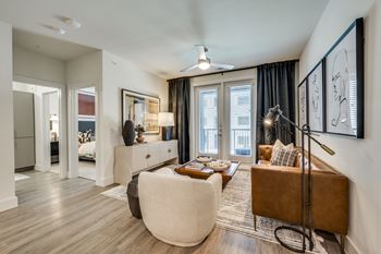 A living room with a brown couch and a white chair.