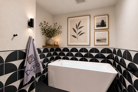 A bathroom with a black and white tiled wall and a white bathtub.