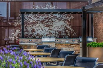 A restaurant with tables and chairs in front of a wall with a tree mural.