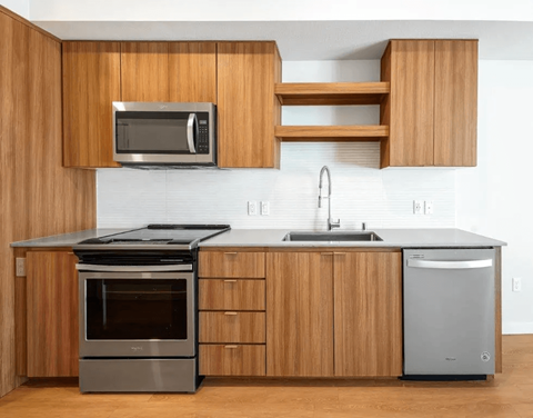 A modern kitchen with wooden cabinets and stainless steel appliances.