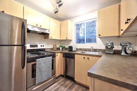 a kitchen with stainless steel appliances and wooden cabinets