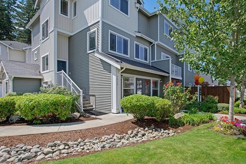 A grey two story house with a front yard.