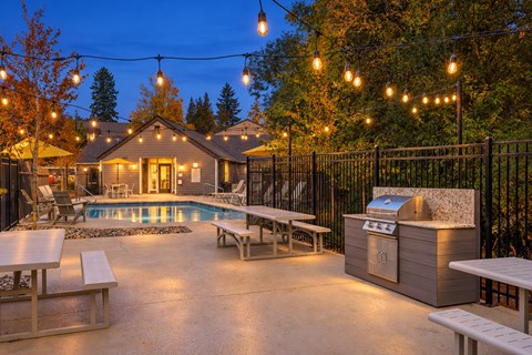 A backyard with a pool and a grill.