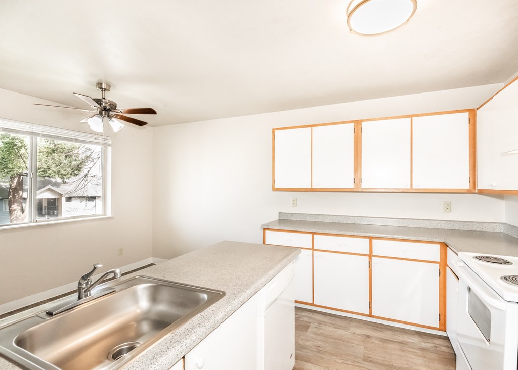 A kitchen with a white stove and a window.