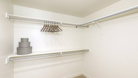 A white closet with a shelf and a hanger.