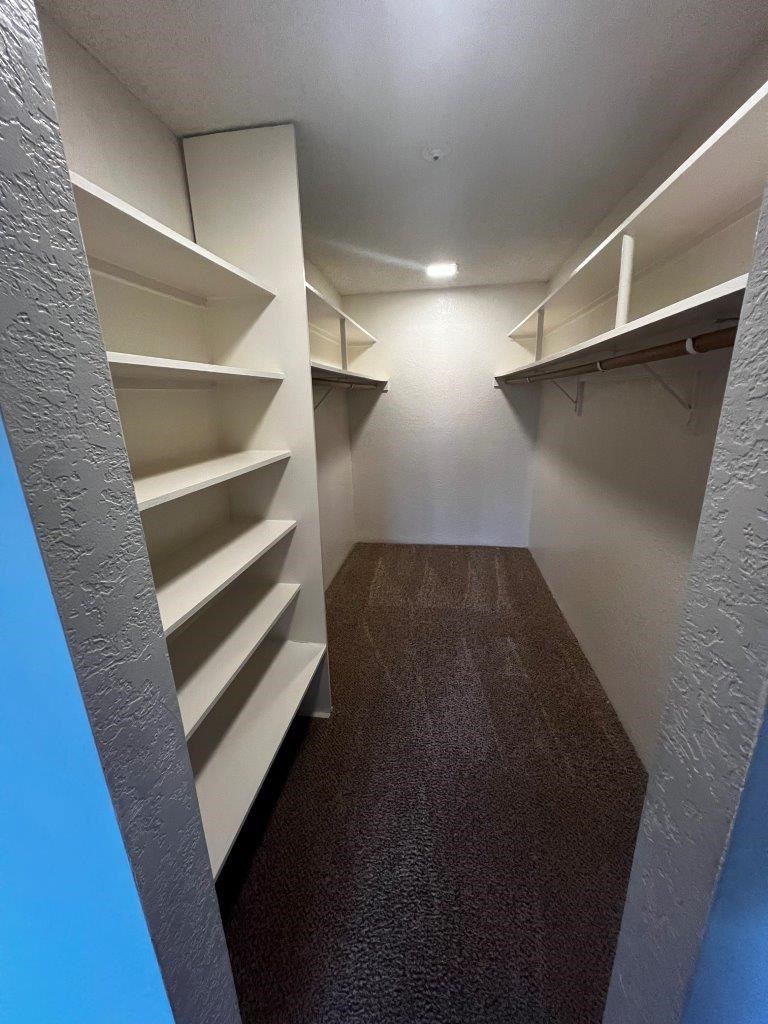 A long hallway with shelves on the side.