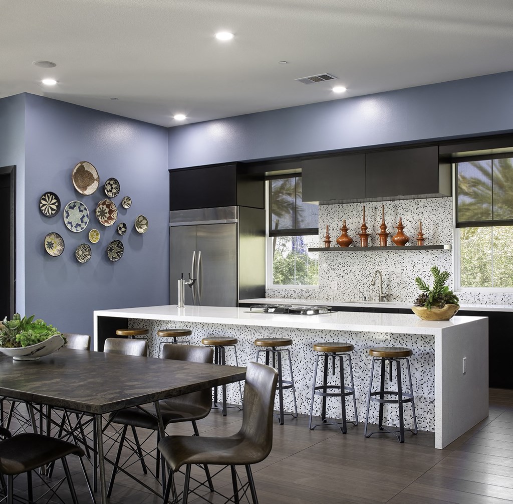a modern kitchen with a dining area and a bar with stools