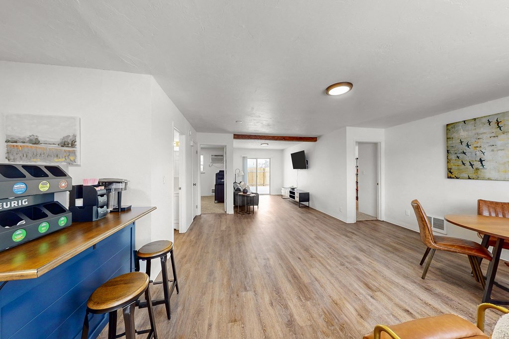 Creekside Apartments the living room and dining room of a house with wood flooring and a bar
