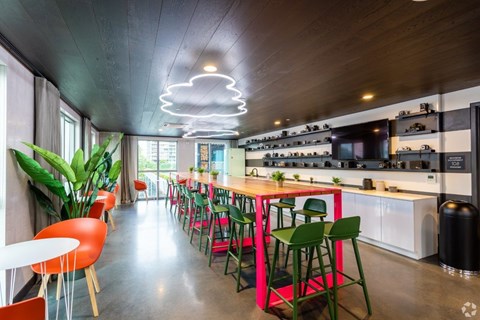 A modern kitchen with a long table and chairs.