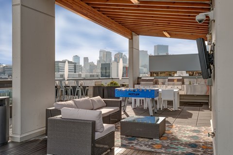 A patio with a table and chairs and a view of the city.