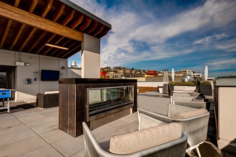 A rooftop patio with chairs and a bar.