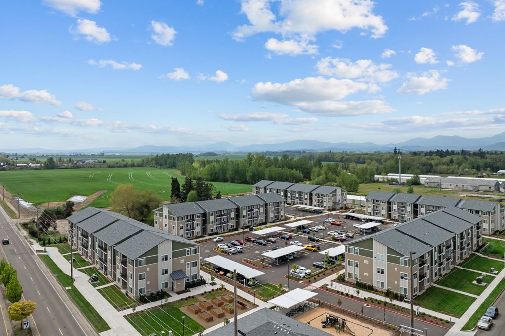 A large apartment complex with a parking lot in front.
