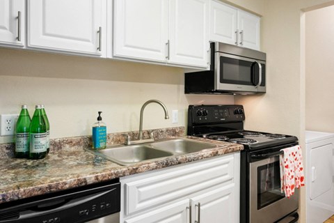 a kitchen with a sink and a stove and a microwave